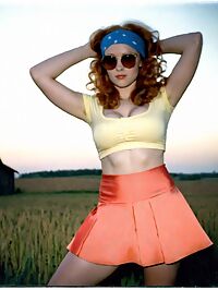 Woman in 1970s attire sporting ginger locks and D cup breasts in an old farmhouse
